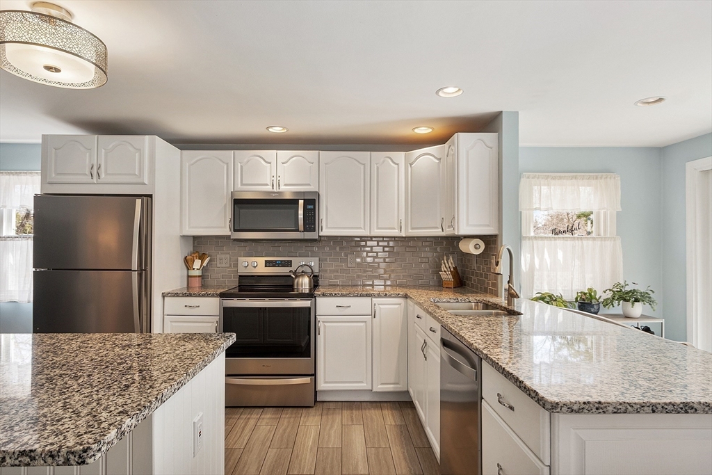 24 Washington Avenue Ashland, MA 01721 - Photo 5 of 30 a kitchen with stainless steel appliances granite countertop a sink stove and refrigerator