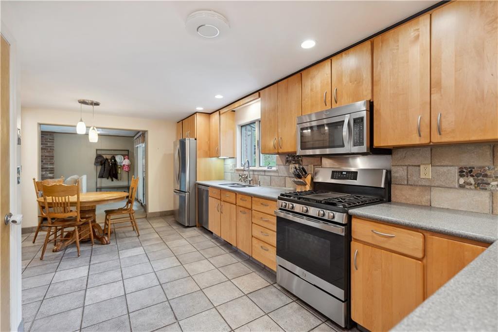 2 Lear Drive Pittsburgh, PA 15235 - Photo 12 of 43 a kitchen with stainless steel appliances granite countertop a stove a sink dishwasher and a microwave oven with cabinets
