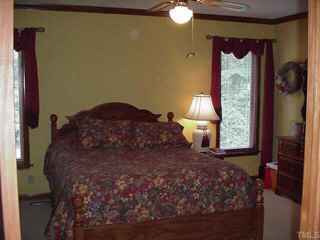 4506 Pearces Road Zebulon, NC 27597 - Photo 8 of 10 a large bed sitting in a bedroom next to a window