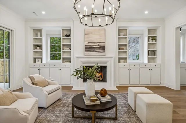 a living room with furniture a fireplace and large windows