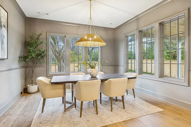 a dining room with furniture a chandelier and wooden floor