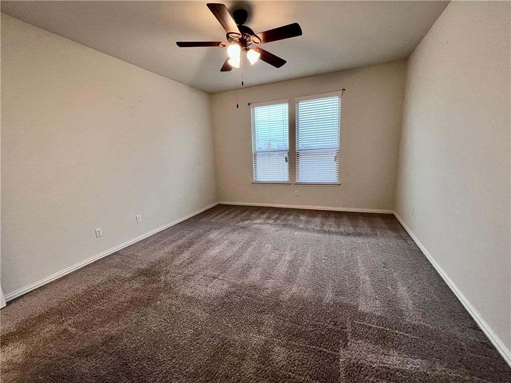 19733 Cherubini Trail Pflugerville, TX 78660 - Photo 15 of 24 Spare room featuring dark carpet and a ceiling fan