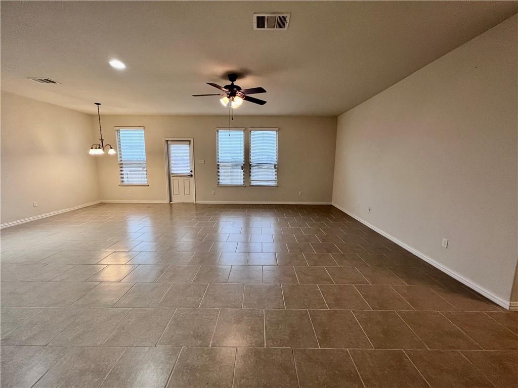 19733 Cherubini Trail Pflugerville, TX 78660 - Photo 2 of 24 Empty room with a ceiling fan and a chandelier