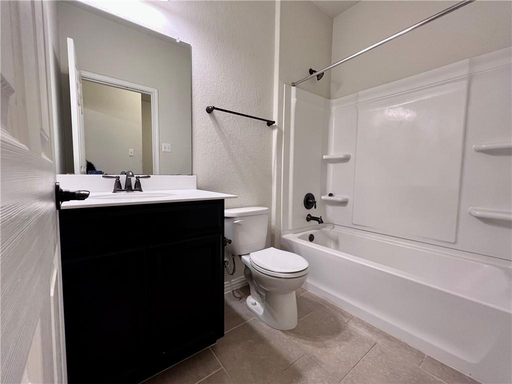 19733 Cherubini Trail Pflugerville, TX 78660 - Photo 21 of 24 Full bath with a textured wall, vanity, shower / bathtub combination, and light tile patterned floors