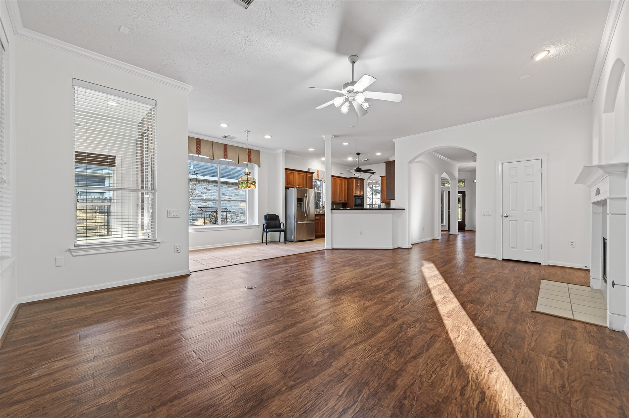 27 Sovereign Way Conroe, TX 77384 - Photo 12 of 49 This spacious, open-concept living area features beautiful hardwood floors, abundant natural light from large windows, and a ceiling fan.