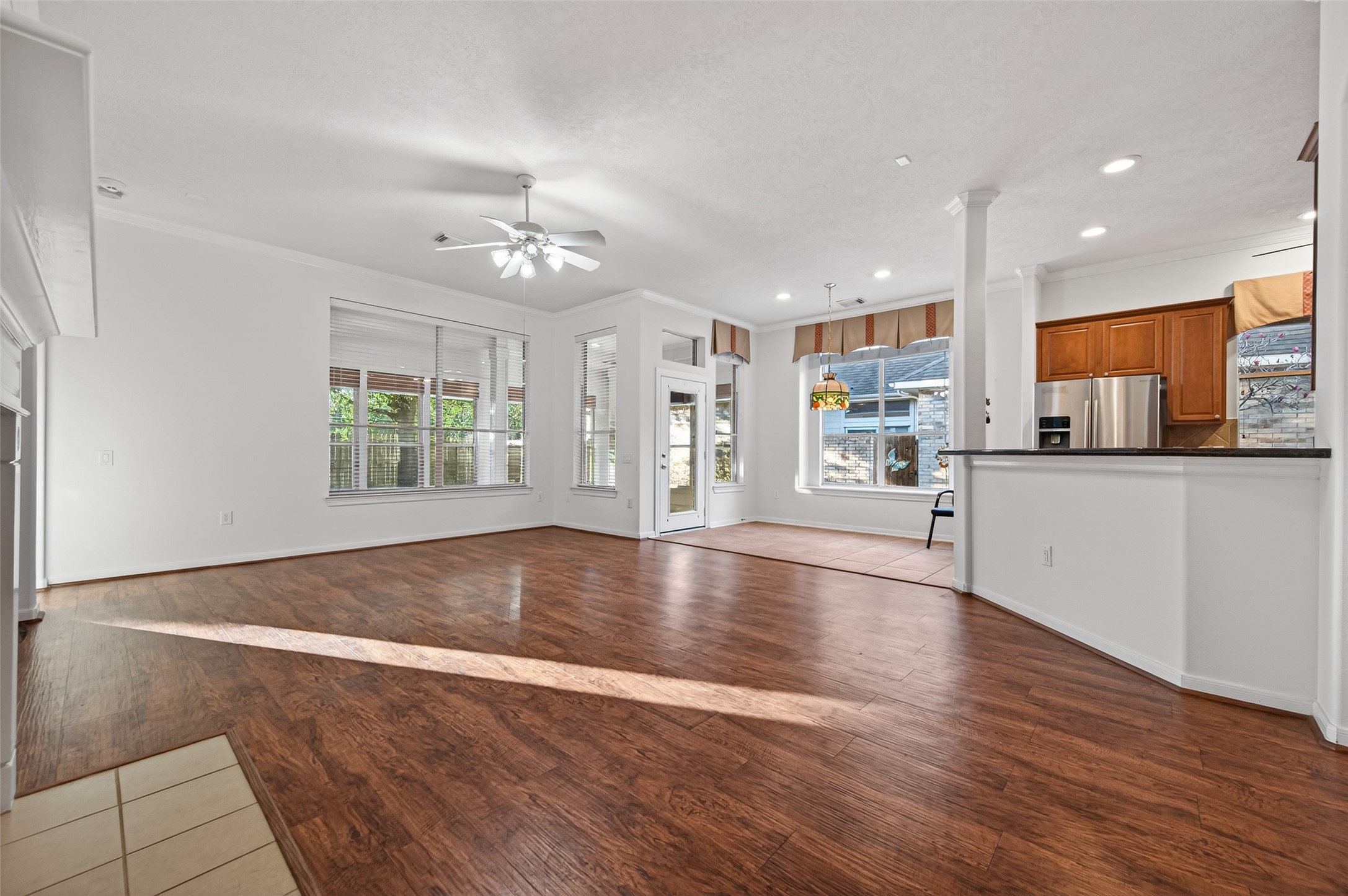 27 Sovereign Way Conroe, TX 77384 - Photo 13 of 49 Spacious, open-concept living area with beautiful hardwood floors and abundant natural light from large windows. Perfect for entertaining and family gatherings.