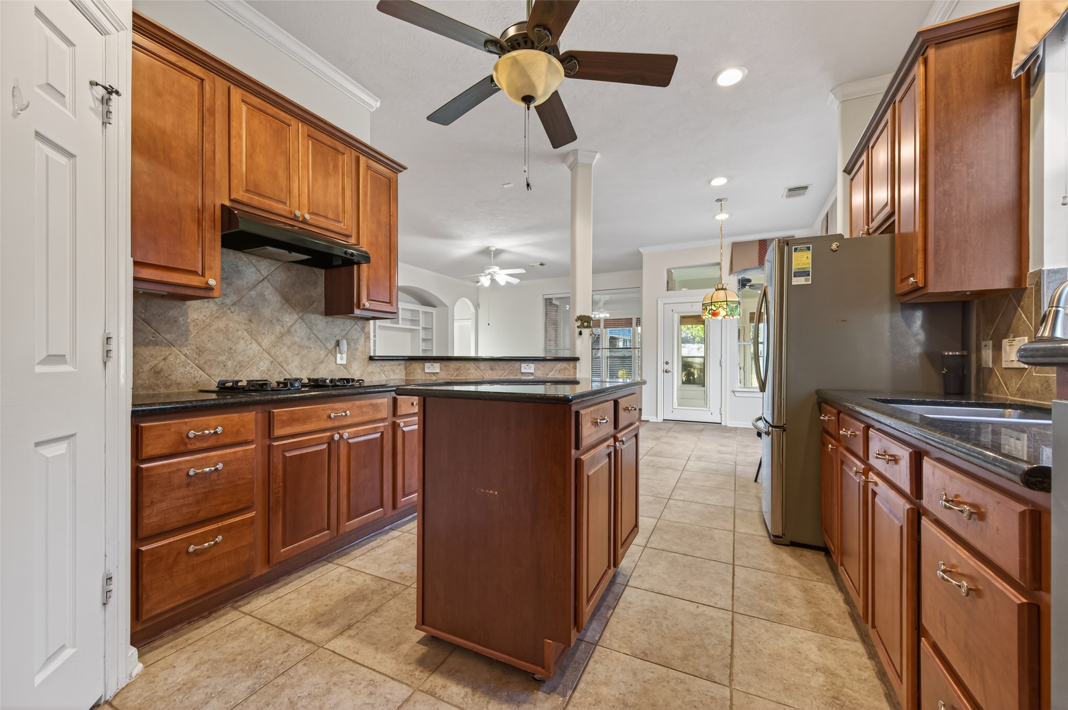 27 Sovereign Way Conroe, TX 77384 - Photo 15 of 49 This kitchen features warm wooden cabinetry, a central island (on wheels), and modern appliances.