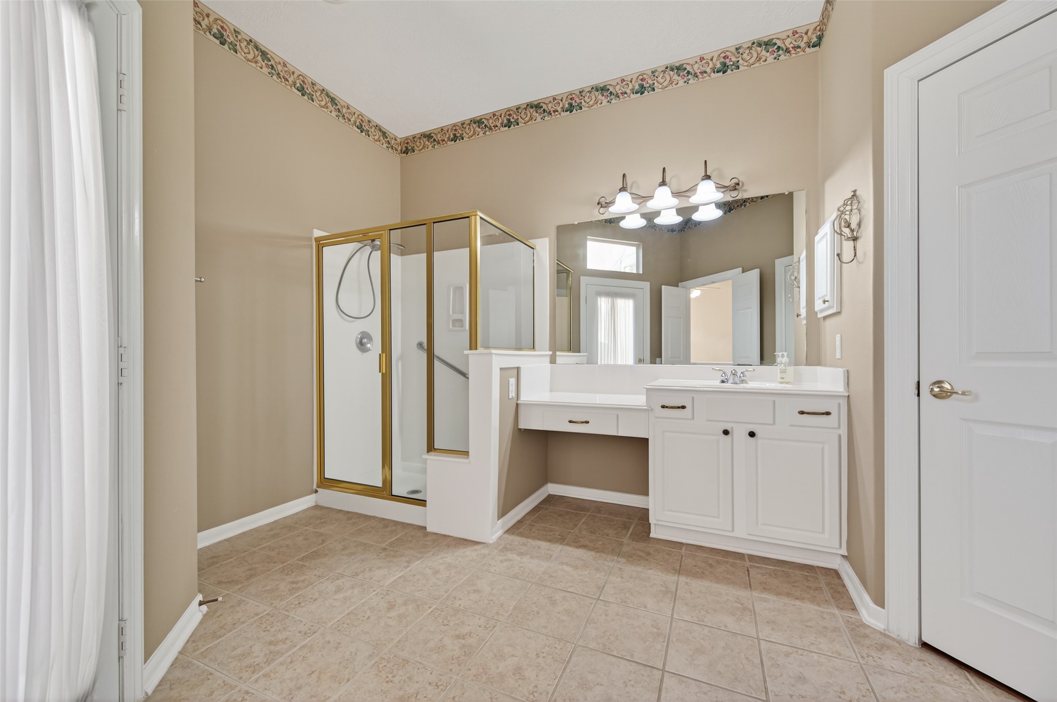 27 Sovereign Way Conroe, TX 77384 - Photo 25 of 49 This bathroom features a spacious layout with a corner shower, a large vanity with ample counter space and storage, and a well-lit mirror area.