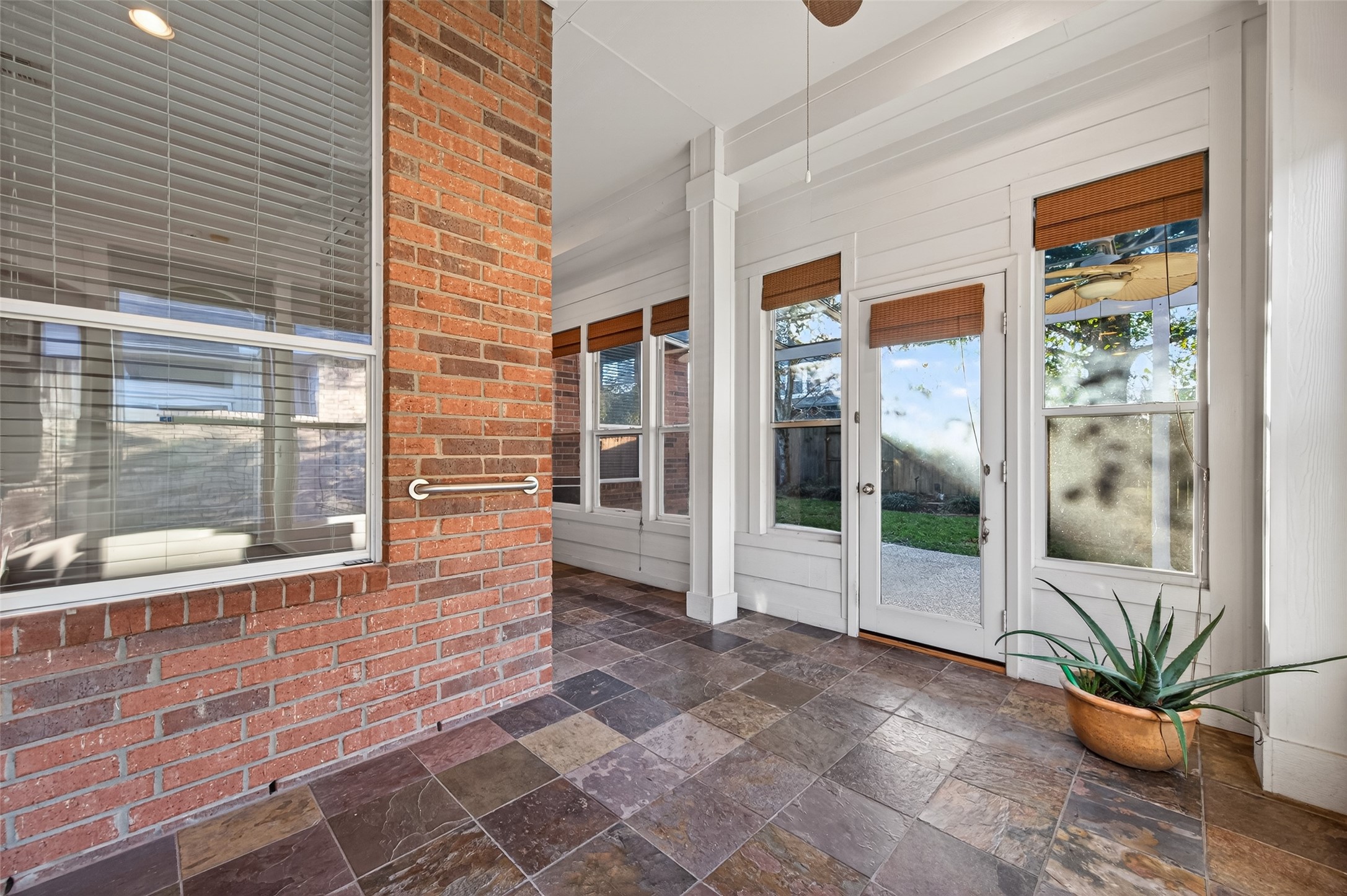 27 Sovereign Way Conroe, TX 77384 - Photo 32 of 49 This photo features a bright sunroom with large windows and a glass door, offering a view of the backyard.