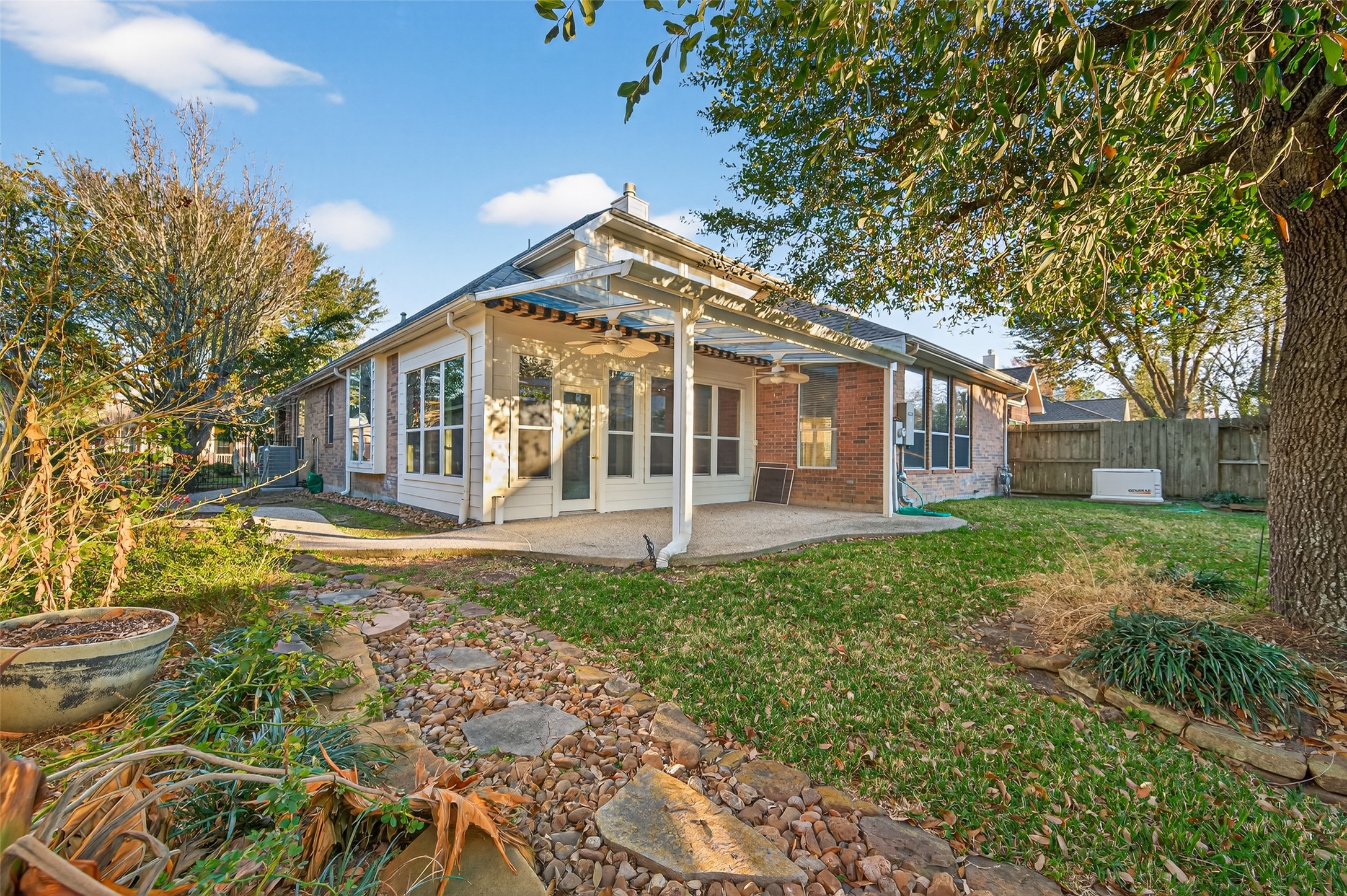 27 Sovereign Way Conroe, TX 77384 - Photo 35 of 49 This charming home features a spacious backyard with a stone pathway, lush greenery, and a covered patio perfect for outdoor relaxation.