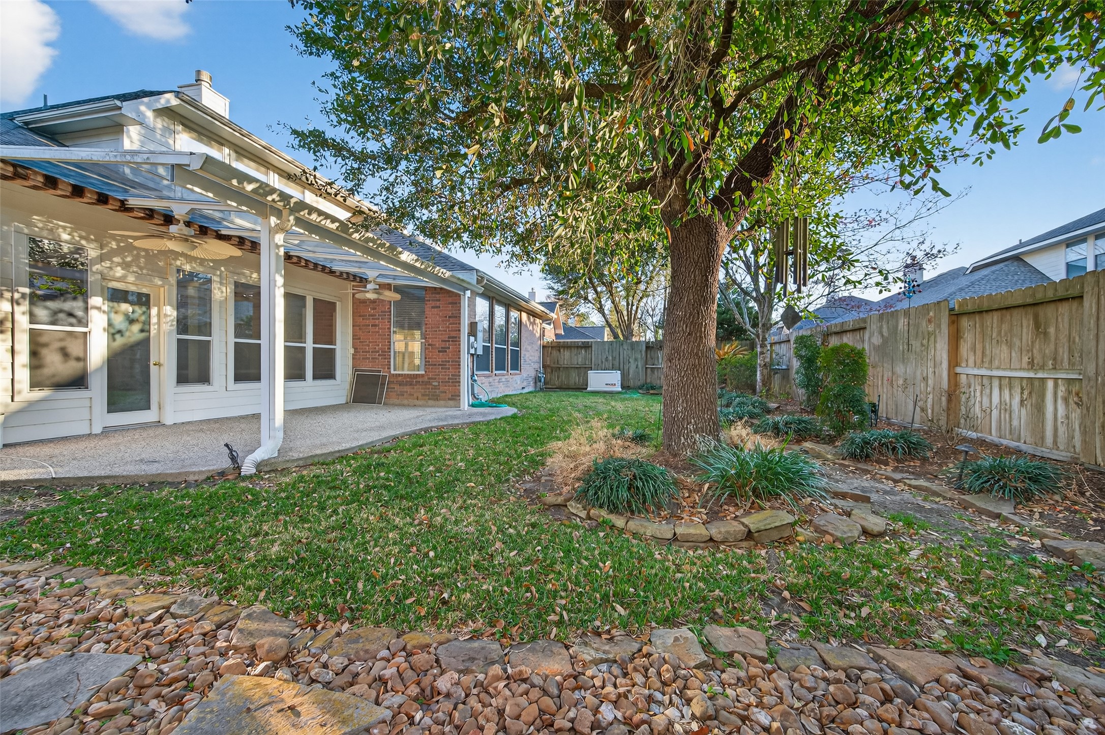 27 Sovereign Way Conroe, TX 77384 - Photo 36 of 49 Charming backyard with a spacious patio, mature tree, and privacy fencing.