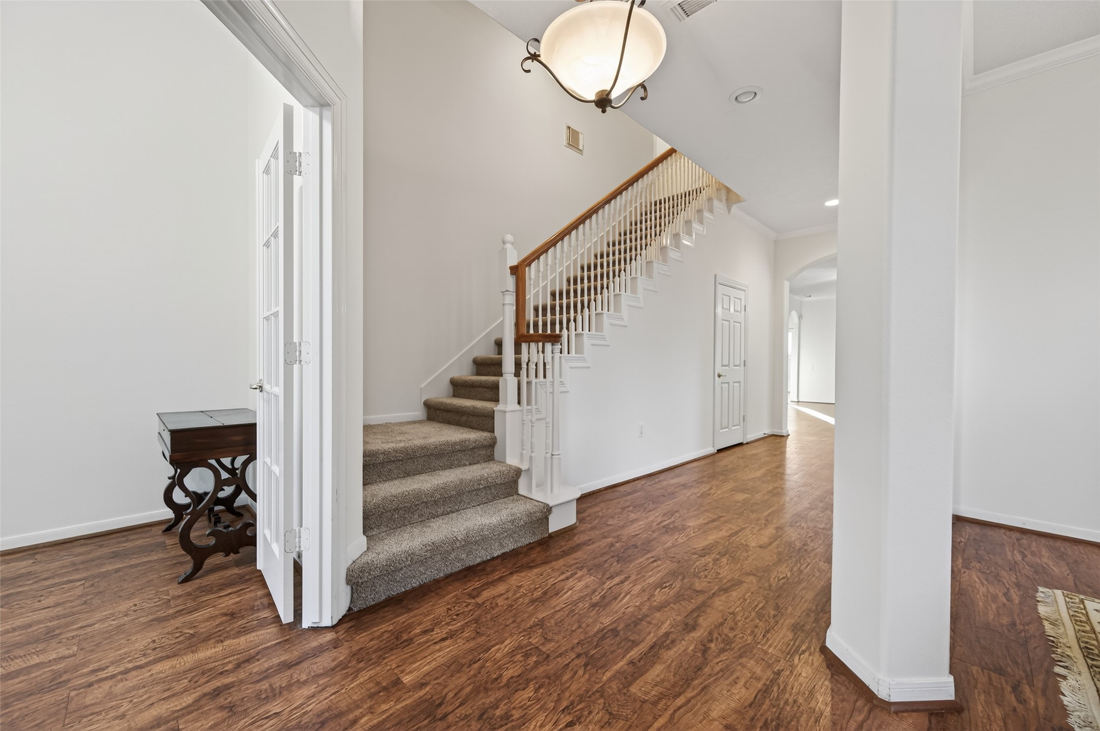 27 Sovereign Way Conroe, TX 77384 - Photo 4 of 49 This entryway features a bright, inviting space with hardwood floors and a carpeted staircase. Carpet replaced in Feb 2026. Half bath under the stairs for guests