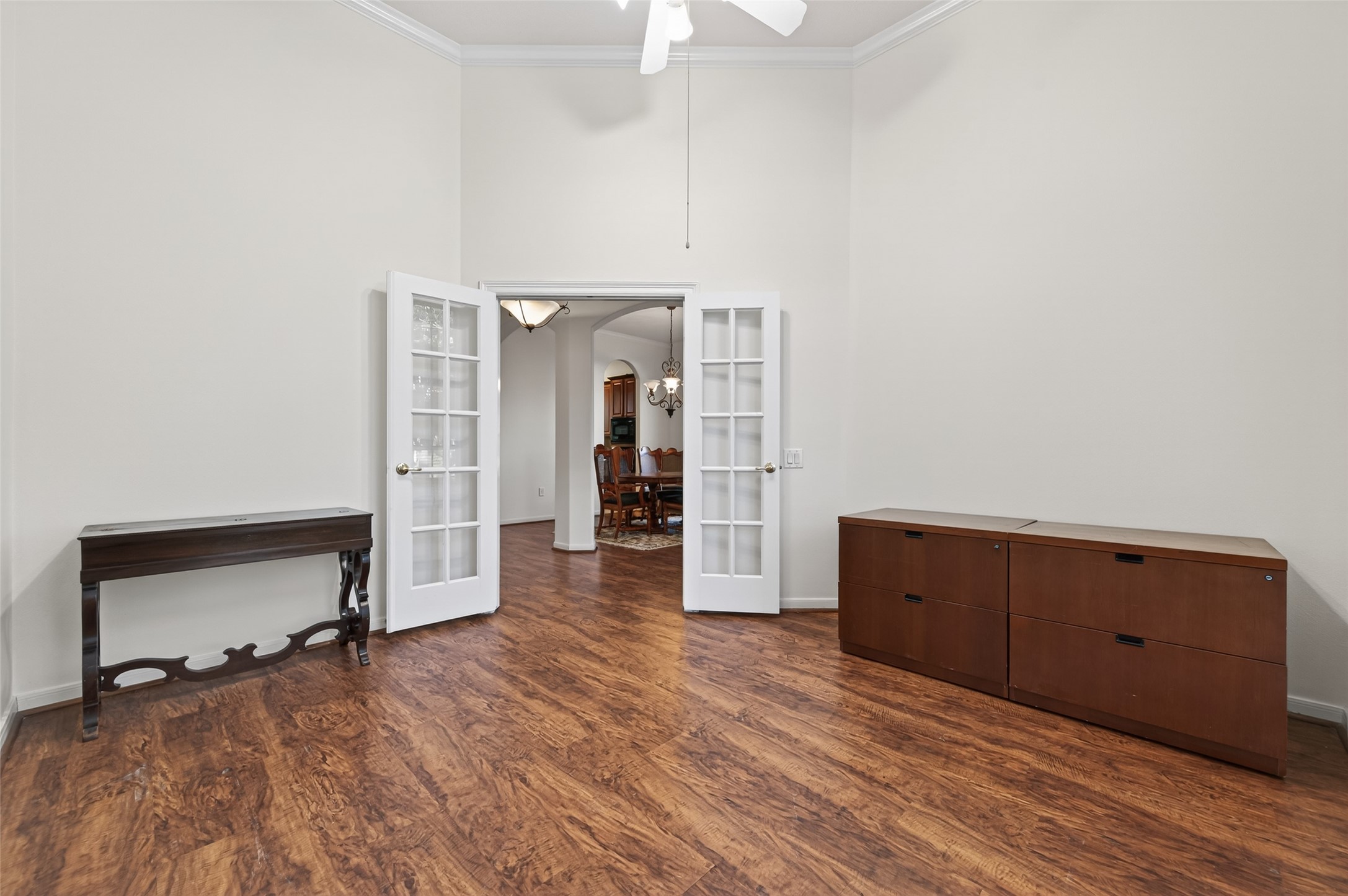 27 Sovereign Way Conroe, TX 77384 - Photo 5 of 49 Spacious home office with elegant wood flooring and neutral walls, featuring French doors that open to the entry