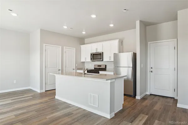 a kitchen with stainless steel appliances a refrigerator and a stove top oven