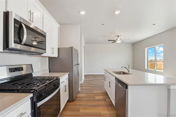 a kitchen with stainless steel appliances granite countertop a stove a sink and a microwave