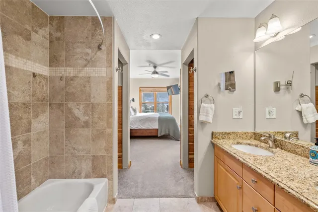 a en suite bathroom with a granite countertop tub sink and shower