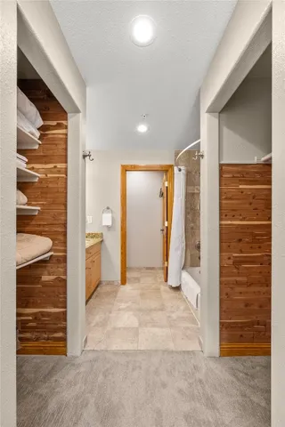 a view of a hallway with wooden shelves