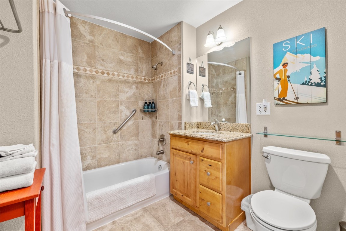 22714 Highway 6, Unit 5989 Keystone, CO 80435 - Photo 19 of 37 a bathroom with a granite countertop sink toilet and painting on the wall