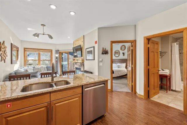 a kitchen with stainless steel appliances granite countertop a sink and dishwasher with wooden floor