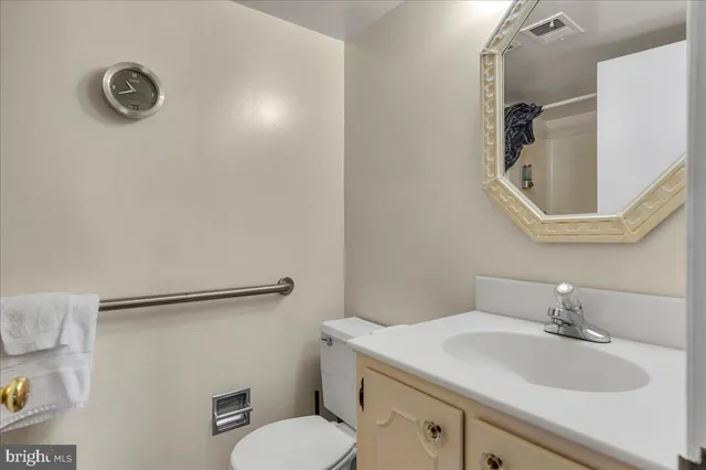a bathroom with a granite countertop sink mirror vanity and toilet