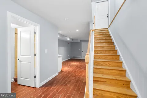 a view of a hallway with wooden floor and entryway