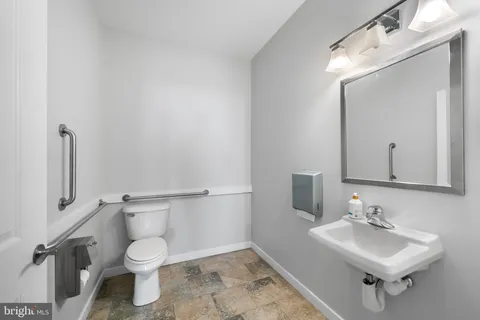 a bathroom with a sink toilet and mirror