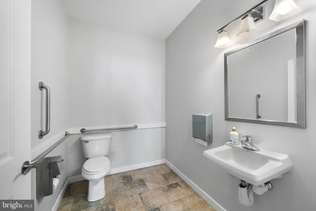 a bathroom with a sink toilet and mirror