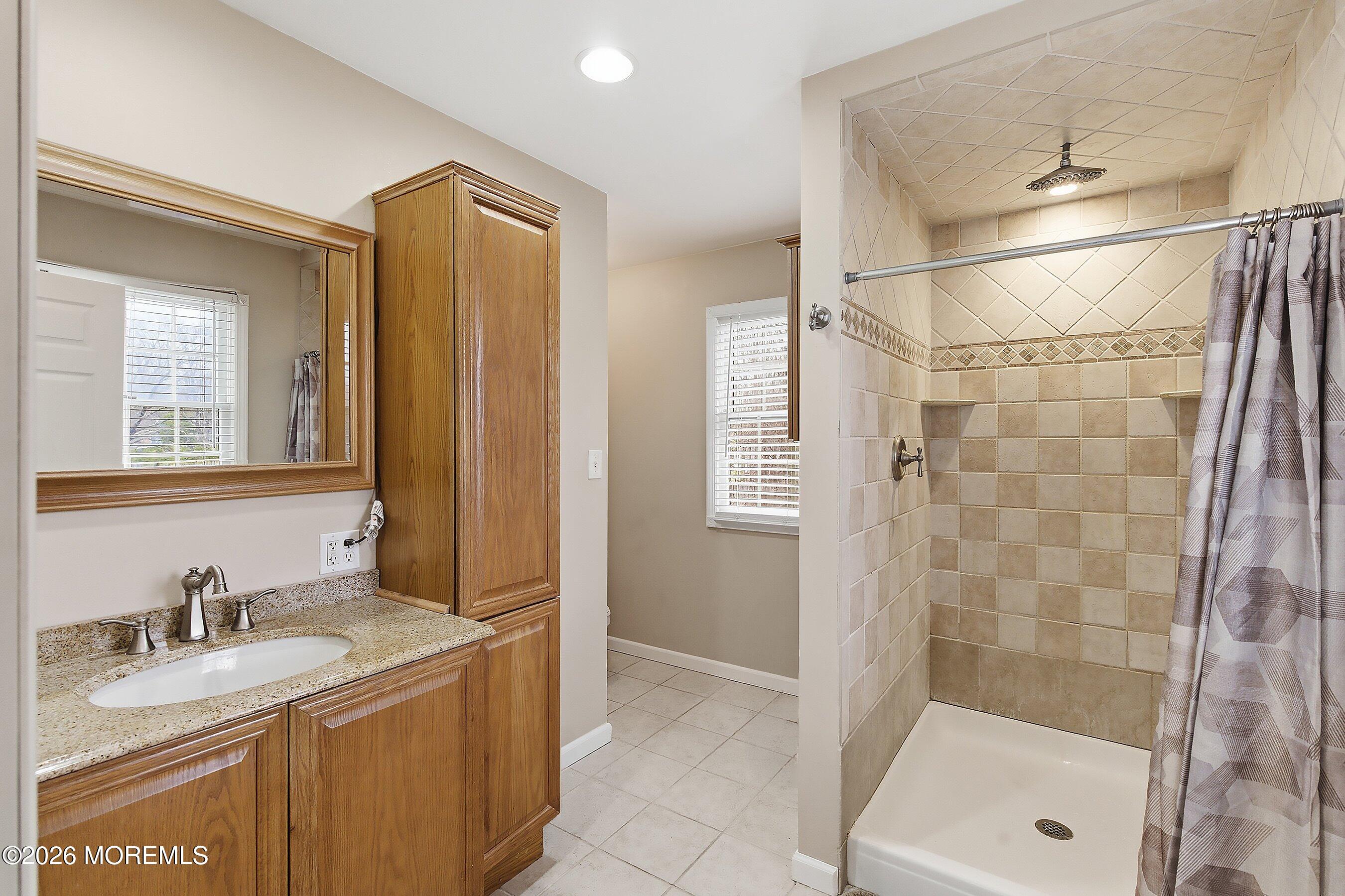 219 Stuart Street Howell, NJ 07731 - Photo 18 of 36 a bathroom with a granite countertop sink a mirror and shower