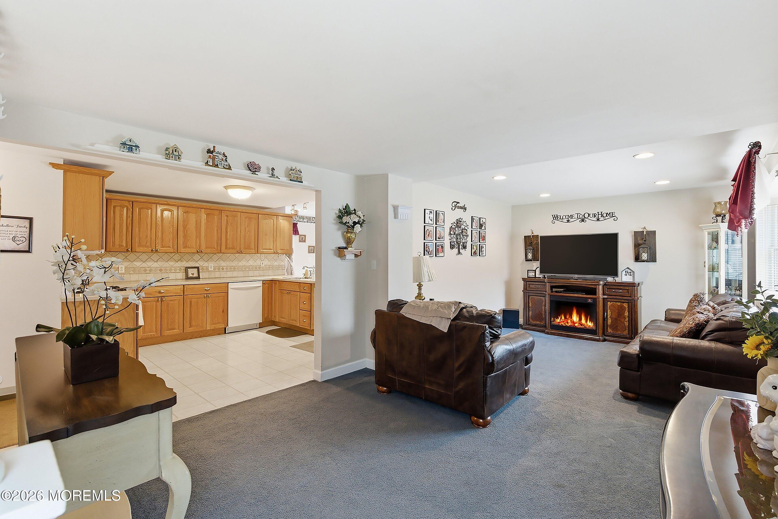 219 Stuart Street Howell, NJ 07731 - Photo 5 of 36 a living room with furniture a flat screen tv and a fireplace
