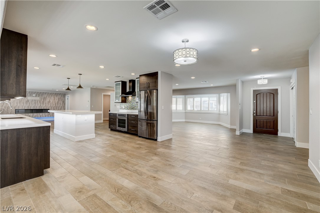 4207 Ridgecrest Drive Las Vegas, NV 89121 - Photo 6 of 27 Kitchen with undermount lighting in kitchen and on island! upgraded tile flooring, and stainless steel appliances!