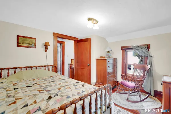 a bedroom with bed and wooden floor