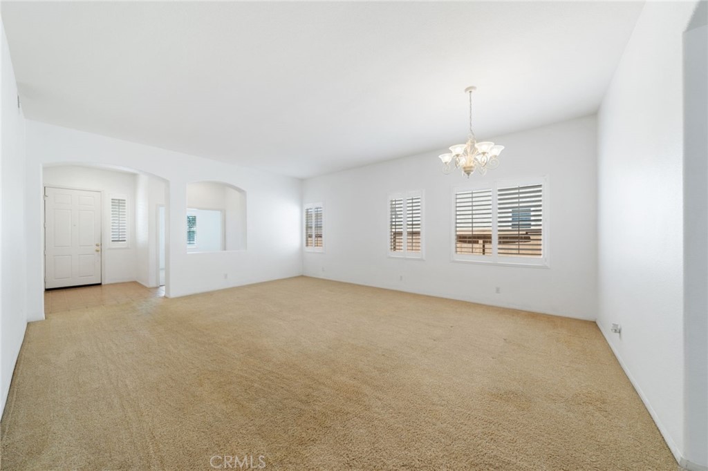 31256 Firestone Street Temecula, CA 92591 - Photo 14 of 56 an empty room with windows and chandelier fan