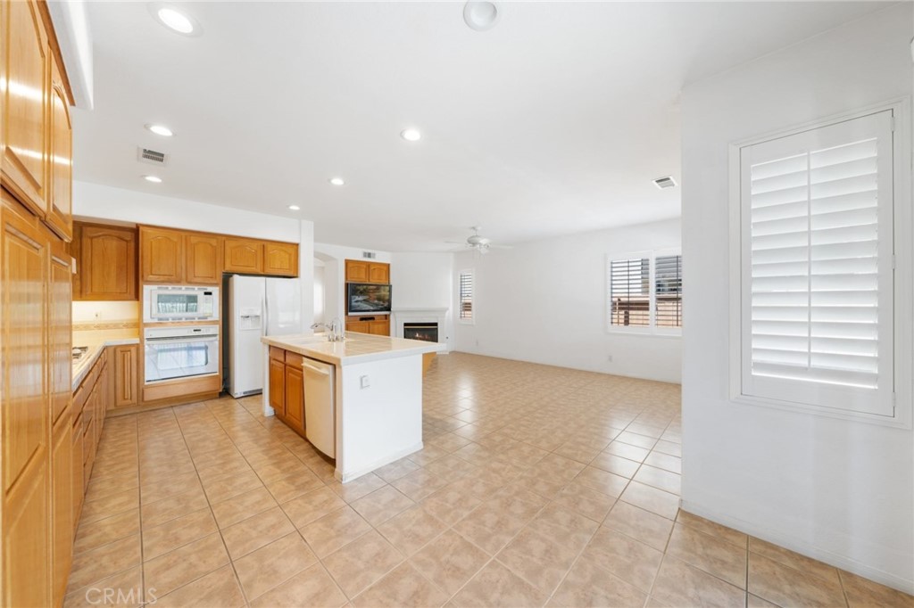 31256 Firestone Street Temecula, CA 92591 - Photo 18 of 56 a view of kitchen with stainless steel appliances kitchen island granite countertop a stove top oven a sink a dining table and chairs