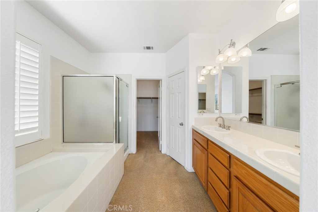 31256 Firestone Street Temecula, CA 92591 - Photo 29 of 56 a spacious bathroom with a tub sink shower and mirror