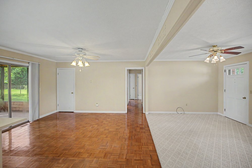 115 Brunson Drive Pickens, SC 29671 - Photo 9 of 29 A well-lit living area offers both plush carpeting and rich wood flooring, perfect for versatile living.