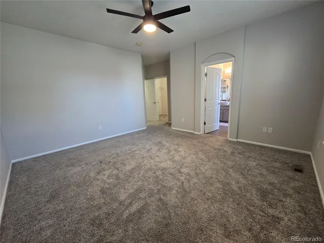 an empty room with closet and windows