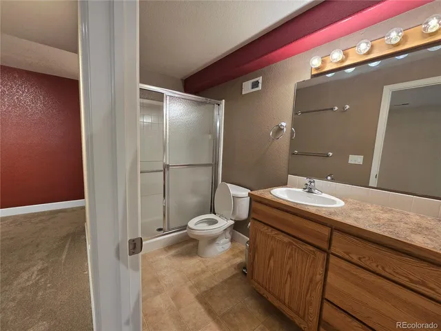 a bathroom with a granite countertop sink toilet and shower