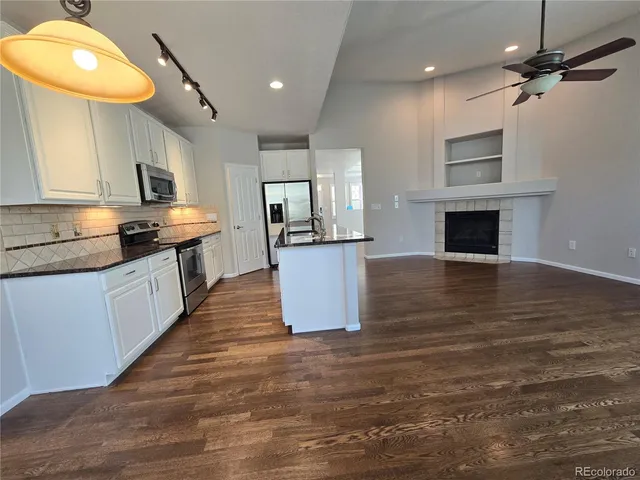 a kitchen with granite countertop a stove top oven a sink a counter space and cabinets
