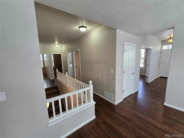 a view of hall way with wooden floor and staircase