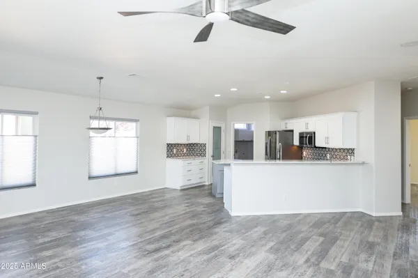 a living room with stainless steel appliances kitchen island hardwood floor and a window