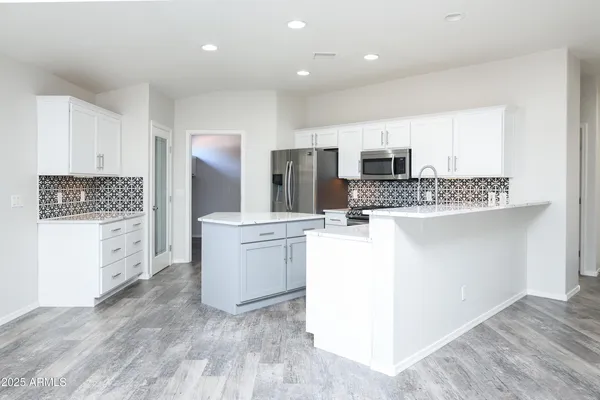 a kitchen with stainless steel appliances a refrigerator and a stove top oven