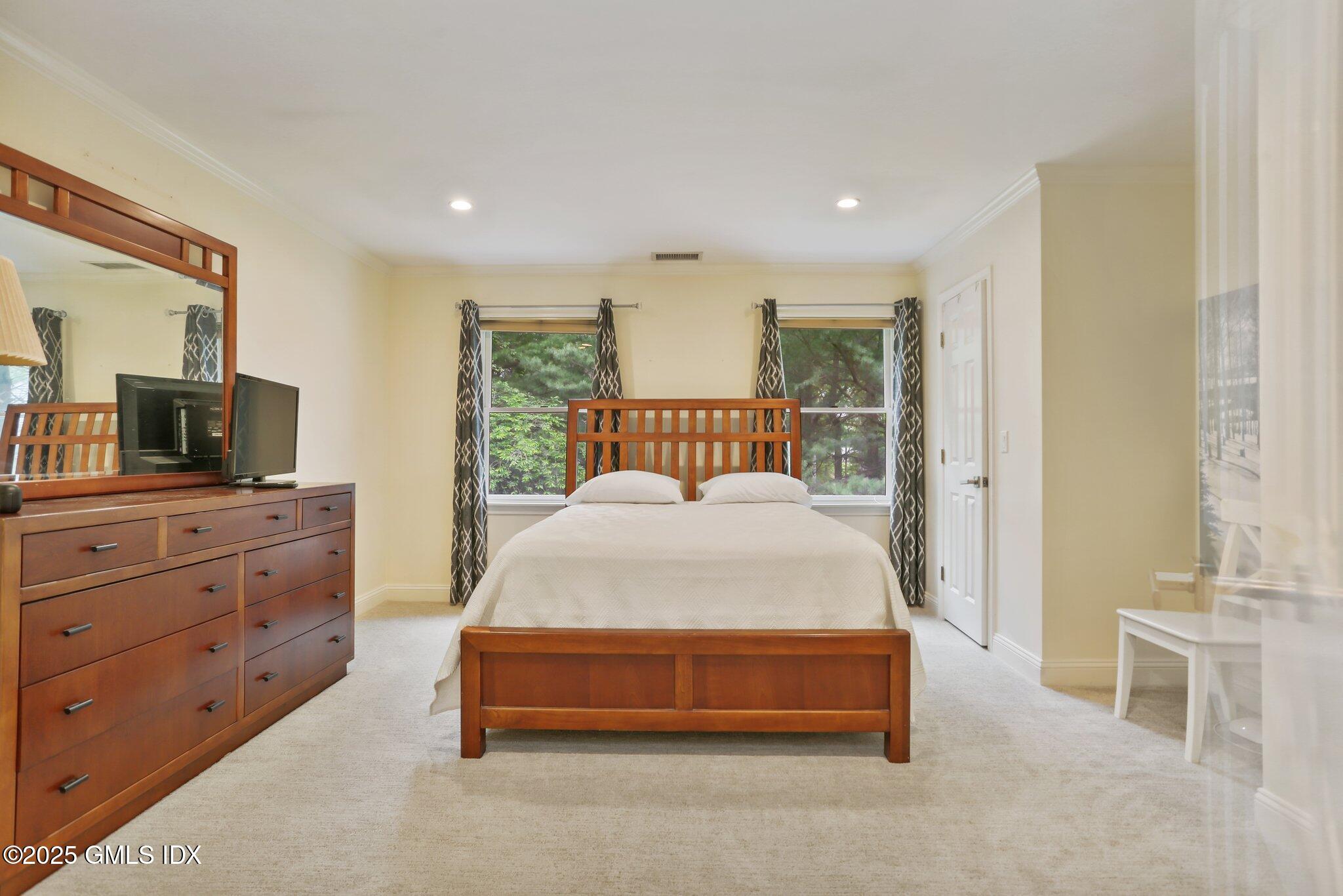112 Old Belden Hill Road Wilton, CT 06897 - Photo 19 of 38 a spacious bedroom with a bed and a flat screen tv
