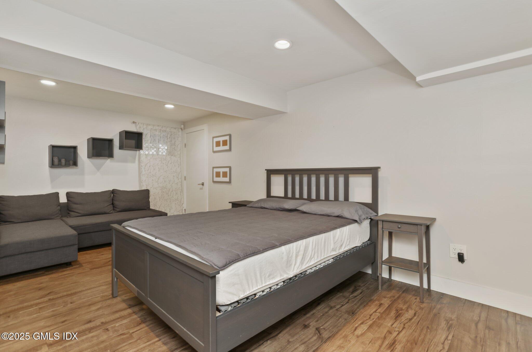 112 Old Belden Hill Road Wilton, CT 06897 - Photo 25 of 38 a spacious bedroom with a bed and a couch