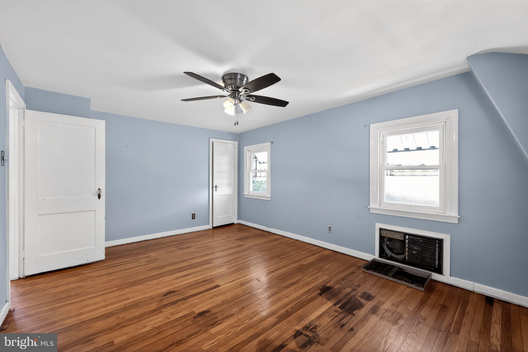 1212 Meadow Road Woodlyn, PA 19094 - Photo 10 of 30 an empty room with wooden floor fireplace and windows