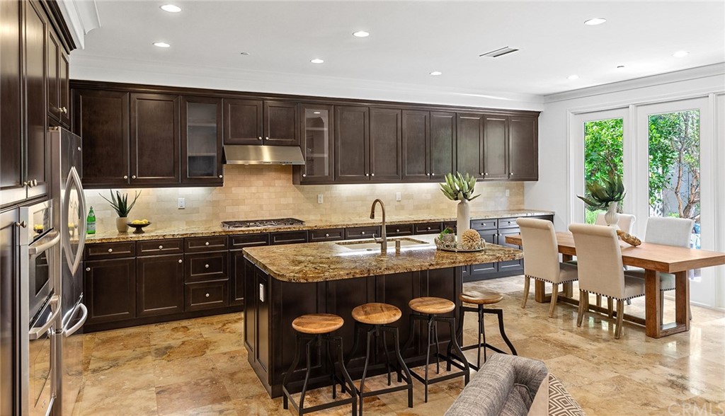 62 Cipresso Irvine, CA 92618 - Photo 11 of 49 a kitchen with granite countertop a stove a sink and a dining table
