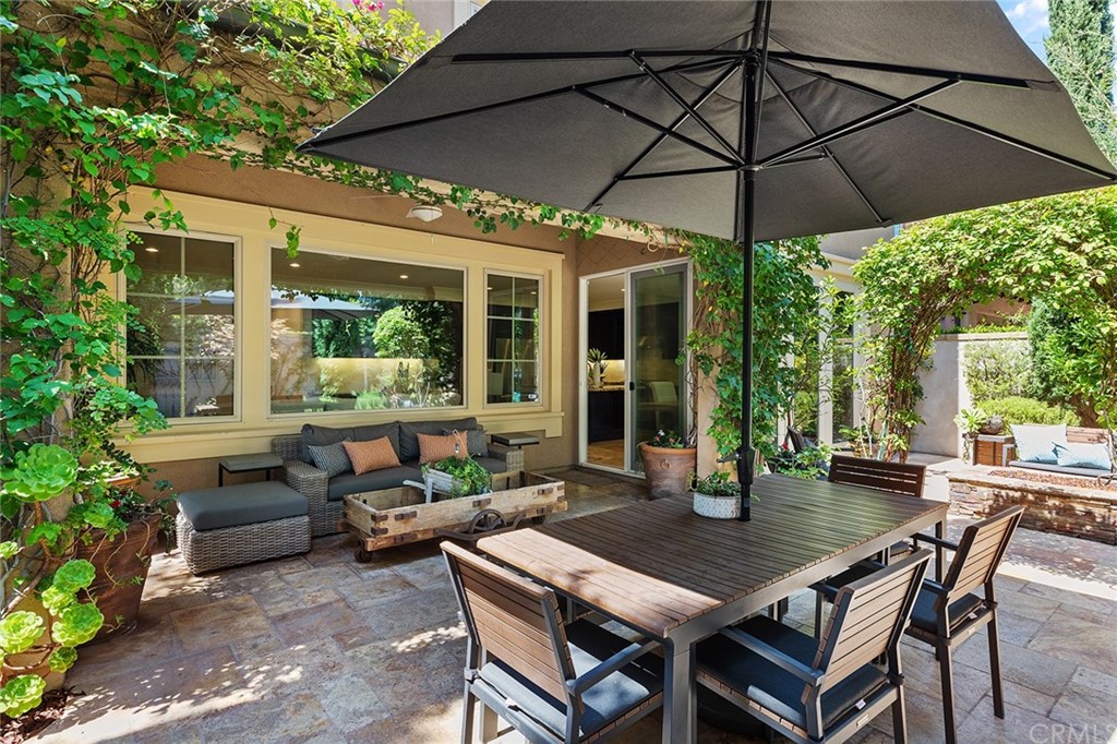 62 Cipresso Irvine, CA 92618 - Photo 28 of 49 a patio with a table and chairs under an umbrella