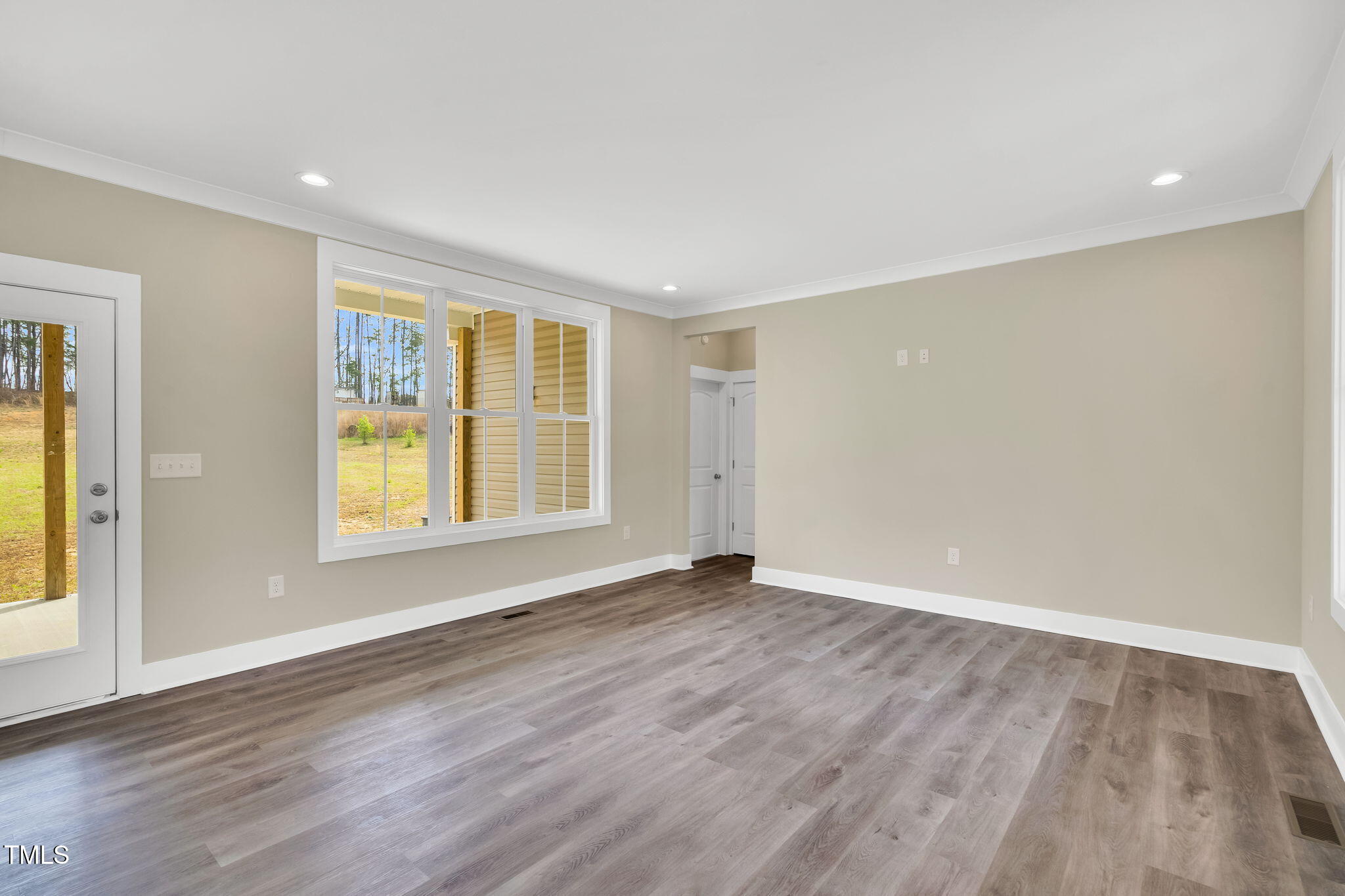 1076 Highway 55 Coats, NC 27521 - Photo 8 of 20 an empty room with wooden floor and windows