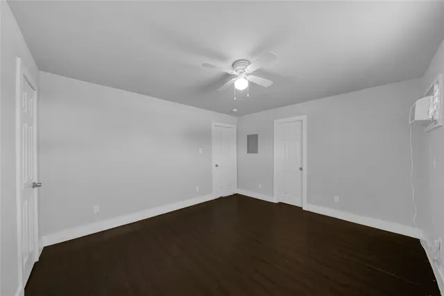 an empty room with a ceiling fan and wooden floor