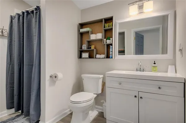 a bathroom with a toilet a sink a vanity and mirror