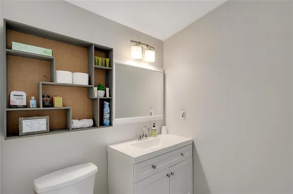 a bathroom with a sink a toilet and a mirror
